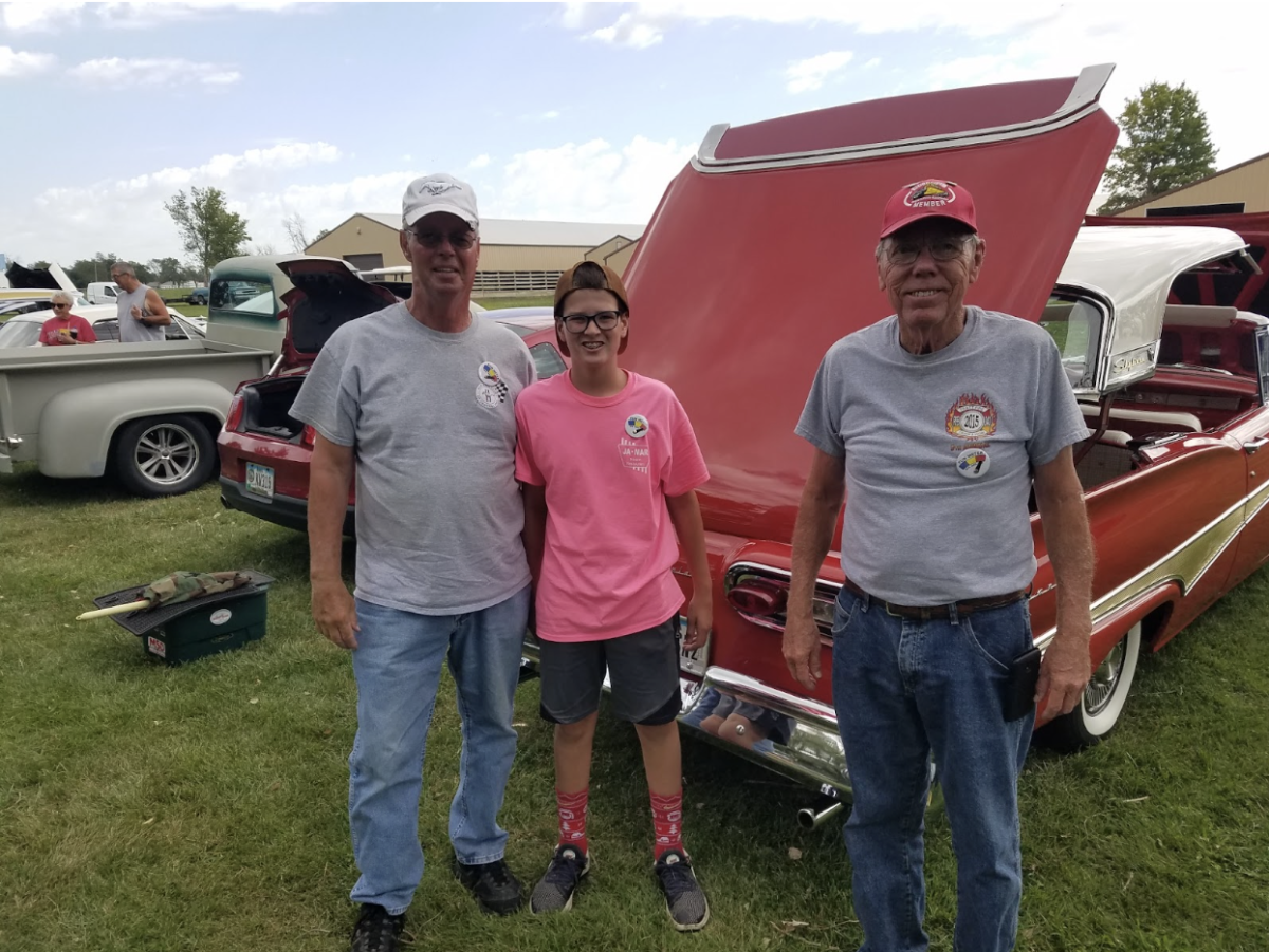 Young Ben Klitgaard '26 at a car show with his father and grandfather.